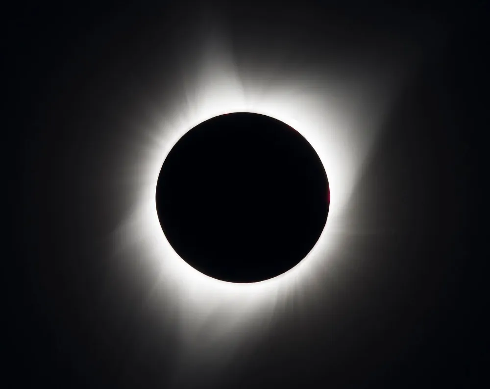 Eclipse solar total, com a coroa do Sol brilhando ao redor do disco escuro da Lua
